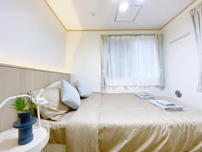 a small bedroom with a bed and a window at nestay villa tokyo takanawa in Tokyo