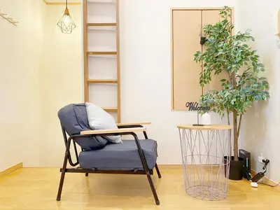 a chair in a living room with a plant at nestay villa tokyo takanawa in Tokyo