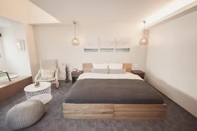 a bedroom with a large bed and a chair at Monoka Hotel Ginza in Tokyo