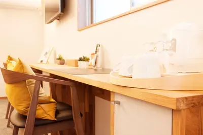 a kitchen with a wooden counter with a yellow pillow at Monoka Hotel Ginza in Tokyo