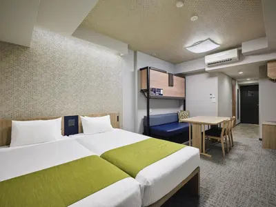 a hotel room with a large bed and a desk at MONday Apart Premium UENO in Tokyo