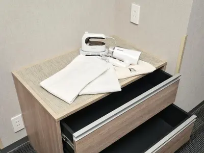 a counter with a sewing machine on top of it at MONday Apart Premium Ginza Shintomicho in Tokyo