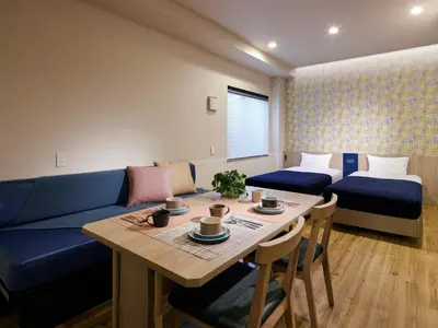 a living room with a blue couch and a table at Minn Kasai in Tokyo