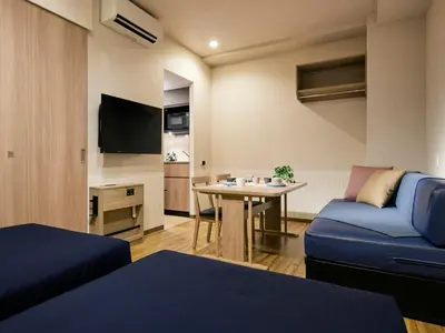 a living room with a blue couch and a table at Minn Kasai in Tokyo