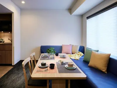 a living room with a table and a blue couch at Minn Kasai in Tokyo