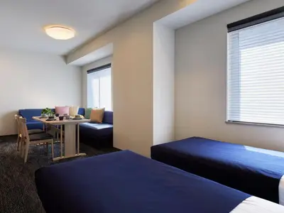 a hotel room with two beds and a table at Minn Kasai in Tokyo