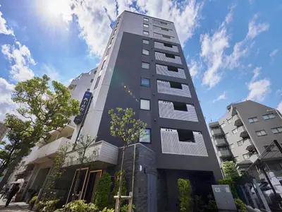 a tall gray building with the sky in the background at Minn Kasai in Tokyo