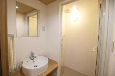 a white bathroom with a sink and a mirror at Uhome Suido Apartment SD in Tokyo