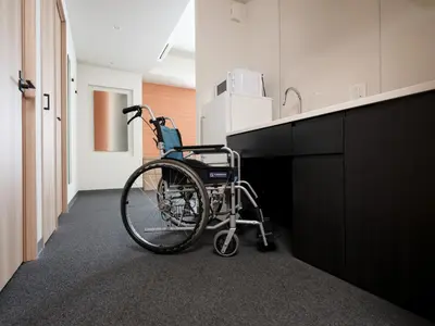 a wheelchair sitting in an office hallway next to a counter at MIMARU Tokyo Asakusa Station in Tokyo