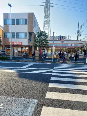 a person riding a bike on a crosswalk in a street at \u6771\u4eac \u8db3\u7acb\u533a\u9752\u4e95 Tokyo Adachiku Aoi in Tokyo