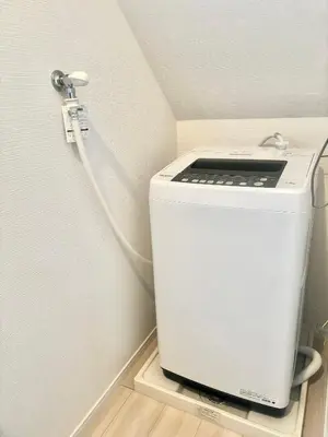 a washing machine with a cord plugged into a wall at \u6771\u4eac \u8db3\u7acb\u533a\u9752\u4e95 Tokyo Adachiku Aoi in Tokyo