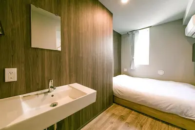a bathroom with a sink and a bed at &AND HOSTEL ASAKUSA KAPPABASHI in Tokyo