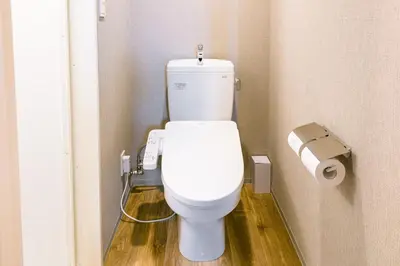 a bathroom with a toilet with a roll of toilet paper at &AND HOSTEL ASAKUSA KAPPABASHI in Tokyo