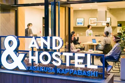 a group of people sitting at tables in a lobby at &AND HOSTEL ASAKUSA KAPPABASHI in Tokyo