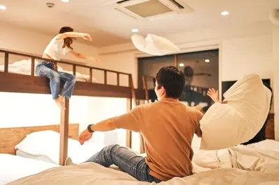 two men are jumping on a bed at Cocts Akihabara in Tokyo