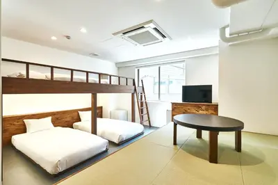 a bedroom with a bunk bed and a table at Cocts Akihabara in Tokyo