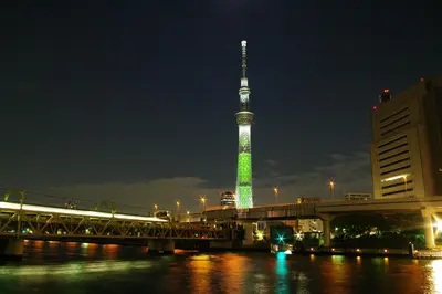 a tv tower is lit up green at night at Cocts Akihabara in Tokyo
