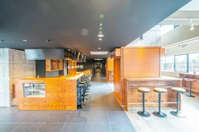 a restaurant with a bar with stools at Wise Owl Hostels River Tokyo in Tokyo