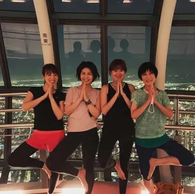 a group of women doing yoga on top of a building at Wise Owl Hostels River Tokyo in Tokyo