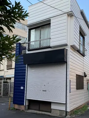 a building with a garage door and a balcony at Peace Inn Skytree Tokyo in Tokyo