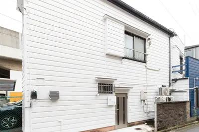 a white building with a door and a window at Peace Inn Skytree Tokyo in Tokyo