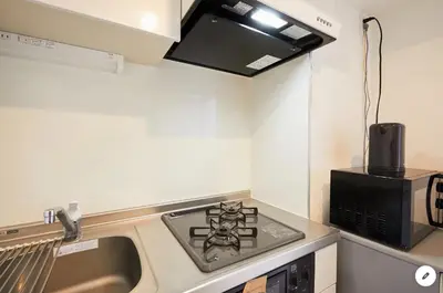 a small kitchen with a stove and a microwave at Marvelous Kinshicho - Vacation STAY 12954v in Tokyo