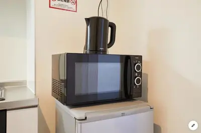 a microwave sitting on top of a refrigerator at Marvelous Kinshicho - Vacation STAY 12956v in Tokyo