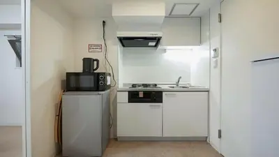 a small kitchen with white cabinets and a microwave at Marvelous Kinshicho - Vacation STAY 12770v in Tokyo