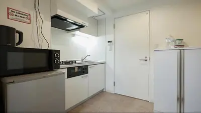 a kitchen with white cabinets and a microwave at Marvelous Kinshicho - Vacation STAY 12770v in Tokyo