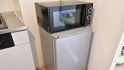 a microwave sitting on top of a refrigerator at Marvelous Kinshicho - Vacation STAY 13097v in Tokyo