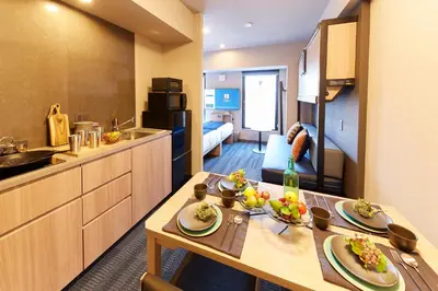 a room with a kitchen and a table with food on it at MONday Apart Asakusabashi Akihabara in Tokyo