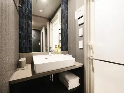 a bathroom with a white sink and a mirror at MONday Apart Asakusabashi Akihabara in Tokyo