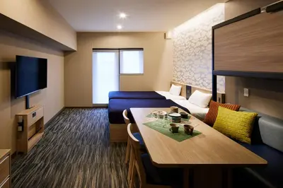 a hotel room with a table and a couch and a room at Minn Akihabara in Tokyo