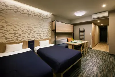 a hotel room with two beds and a desk at Minn Akihabara in Tokyo