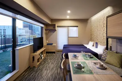 a hotel room with a bed and a table and a room at Minn Akihabara in Tokyo