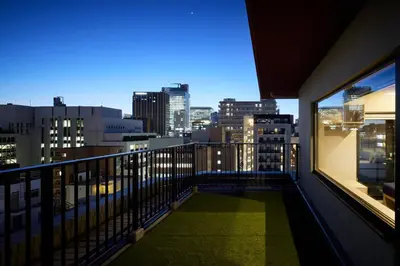 a balcony with a view of a city at night at Minn Akihabara in Tokyo