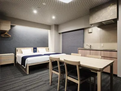 a bedroom with a bed and a table and chairs at MONday Apart Premium UENO OKACHIMACHI in Tokyo