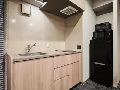 a kitchen with a sink and a black refrigerator at MONday Apart Premium UENO OKACHIMACHI in Tokyo