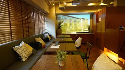 a restaurant with wooden tables and a large window at Sutton Place Hotel Ueno in Tokyo