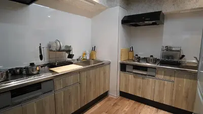a kitchen with wooden cabinets and stainless steel appliances at Sutton Place Hotel Ueno in Tokyo