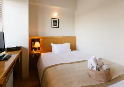 a hotel room with a bed with a desk and a bed sidx sidx sidx sidx at Sutton Place Hotel Ueno in Tokyo