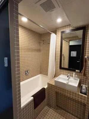 a bathroom with a tub and a sink and a mirror at Sutton Place Hotel Ueno in Tokyo