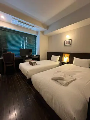 a hotel room with two beds and a television at Sutton Place Hotel Ueno in Tokyo