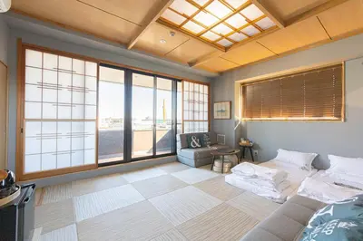 a room with a bed and a couch and windows at \u706f\u5149\u65c5\u9928 Light hotel in Tokyo