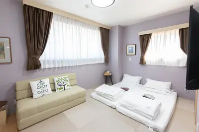 a room with two beds and a couch at \u706f\u5149\u65c5\u9928 Light hotel in Tokyo