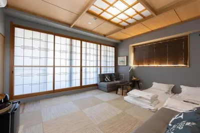 a room with large windows and a couch and a chair at \u706f\u5149\u65c5\u9928 Light hotel in Tokyo