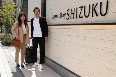 a man and a woman standing in front of a building at Smart Stay SHIZUKU Shinagawa-Oimachi in Tokyo