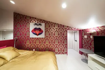 a bedroom with a yellow bed and red wallpaper at La Krasse Skytree in Tokyo