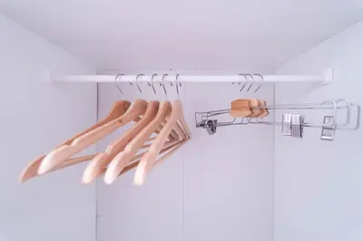 a row of wooden hangers in a closet at SATELLITE HOTEL Ebisu \u30b5\u30c6\u30e9\u30a4\u30c8\u30db\u30c6\u30eb\u6075\u6bd4\u5bff in Tokyo