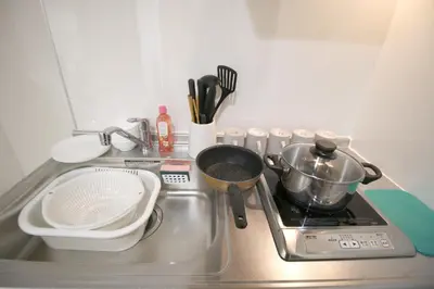 a kitchen stove with a pot on top of it at Uhome\u5343\u99c4\u6728\u9759\u96c5\u6c11\u5bbf\u65c5\u9986 in Tokyo